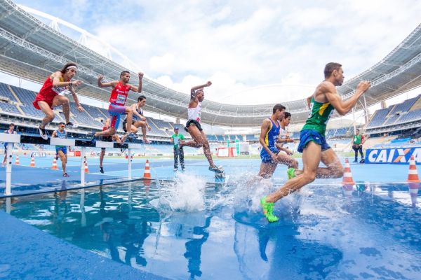 Hardlopers springen over de waterbak tijdens een steeplechase